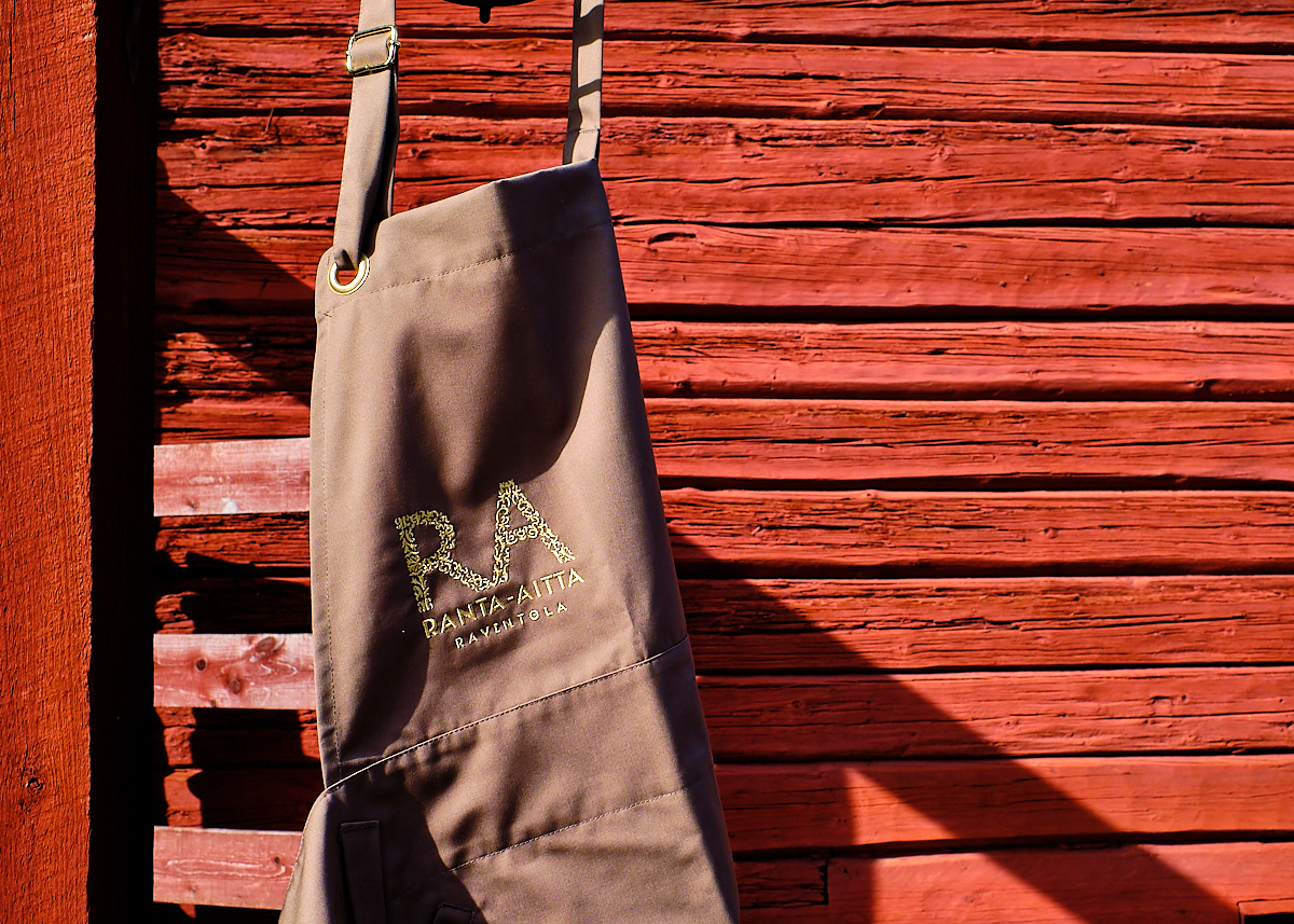 Ranta-Aitta branded apron hanging on a red riverside storehouse in Old Porvoo