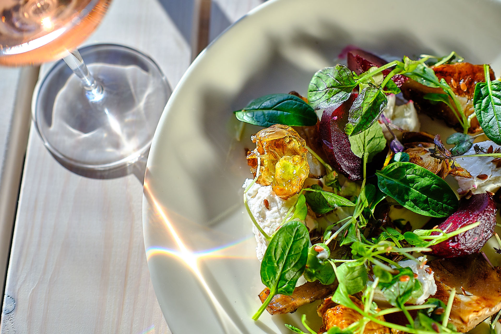 Ranta-Aitta dish with beetroot and greens beside a glass of rosé