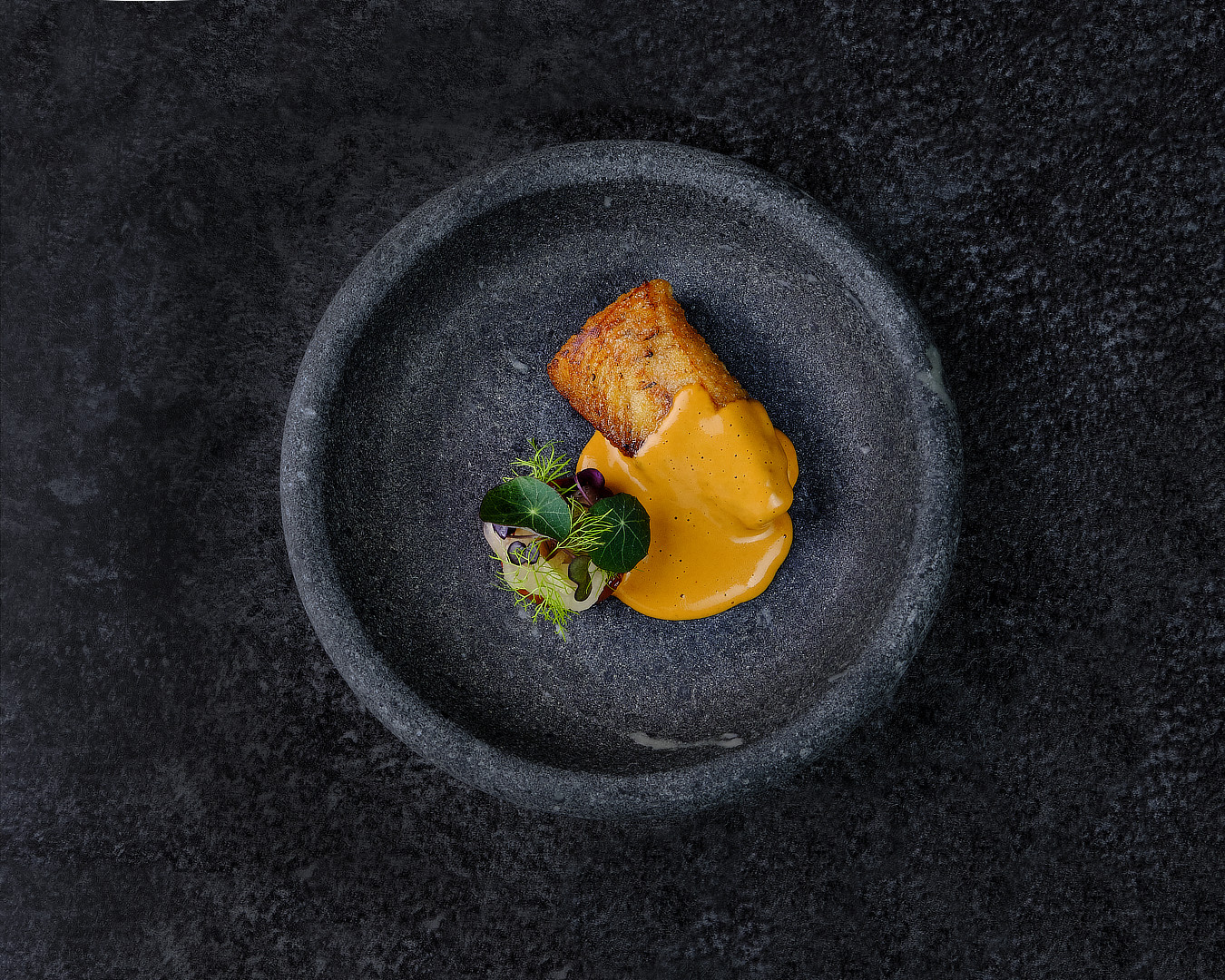 Fried salmon in a dark stone bowl by chef Nico Lehto, the Vår photograph used in the Michelin Guide