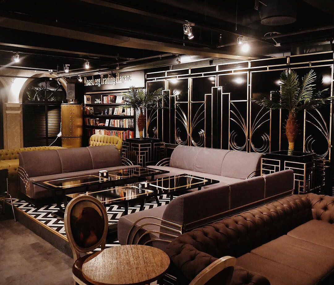 Art deco lounge with velvet sofas and palms